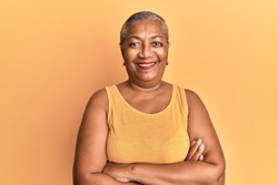 Senior african american woman wearing casual style with sleeveless shirt happy face smiling with crossed arms looking at the camera. positive person. 