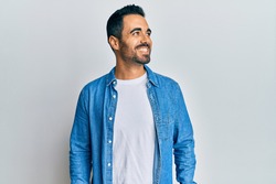 Young hispanic man wearing casual clothes looking to side, relax profile pose with natural face and confident smile. 