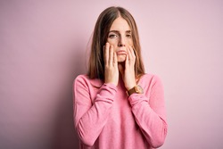 Young beautiful redhead woman wearing casual sweater over isolated pink background Tired hands covering face, depression and sadness, upset and irritated for problem