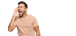 Handsome hispanic man wearing casual clothes shouting and screaming loud to side with hand on mouth. communication concept. 