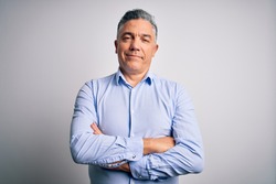 Middle age handsome grey-haired business man wearing elegant shirt over white background happy face smiling with crossed arms looking at the camera. Positive person.