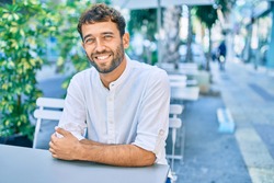 Handsome man with beard wearing casual white shirt on a sunny day smiling happy outdoors