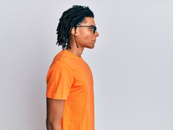 Young african american man wearing casual clothes and glasses looking to side, relax profile pose with natural face with confident smile. 