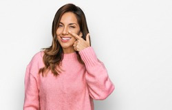 Young hispanic woman wearing casual clothes pointing with hand finger to face and nose, smiling cheerful. beauty concept 