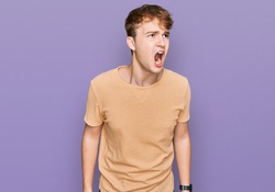 Young caucasian man wearing casual clothes angry and mad screaming frustrated and furious, shouting with anger. rage and aggressive concept. 