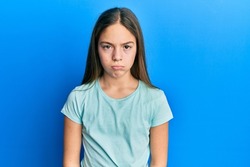 Beautiful brunette little girl wearing casual white t shirt depressed and worry for distress, crying angry and afraid. sad expression. 