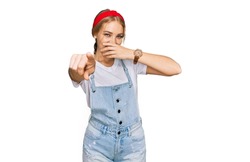 Young caucasian girl wearing casual clothes laughing at you, pointing finger to the camera with hand over mouth, shame expression 