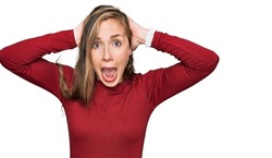 Young blonde woman wearing casual clothes crazy and scared with hands on head, afraid and surprised of shock with open mouth 