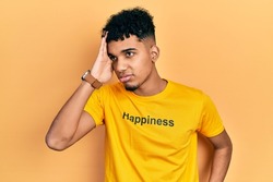 Young african american man wearing t shirt with happiness word message worried and stressed about a problem with hand on forehead, nervous and anxious for crisis 