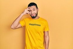 Hispanic man with beard wearing t shirt with happiness word message worried and stressed about a problem with hand on forehead, nervous and anxious for crisis 