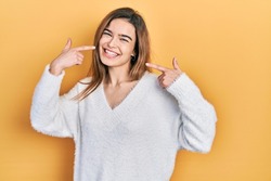 Young caucasian girl wearing casual clothes smiling cheerful showing and pointing with fingers teeth and mouth. dental health concept. 