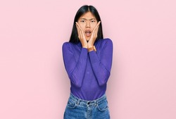 Beautiful young asian woman wearing casual clothes afraid and shocked, surprise and amazed expression with hands on face 