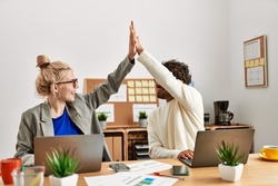 Two business executives raised up hands hitting five at the office.
