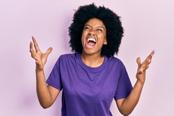 Young african american woman wearing casual clothes crazy and mad shouting and yelling with aggressive expression and arms raised. frustration concept. 