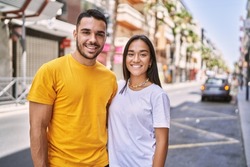 Young latin couple smiling happy and hugging standing at the city.