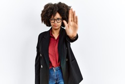 African american woman with afro hair wearing business jacket and glasses doing stop sing with palm of the hand. warning expression with negative and serious gesture on the face. 