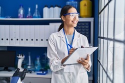 Young african american woman scientist write on report document at laboratory