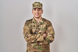 Young arab man wearing camouflage army uniform happy face smiling with crossed arms looking at the camera. positive person. 