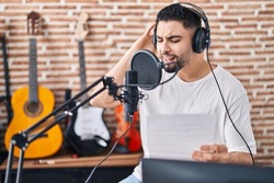 Young arab man artist singing song at music studio