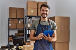 Young hispanic man business worker using touchpad at storehouse