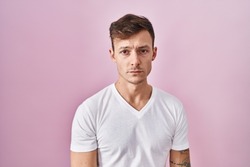 Caucasian man standing over pink background depressed and worry for distress, crying angry and afraid. sad expression. 