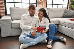 Man and woman couple smiling confident using touchpad at home
