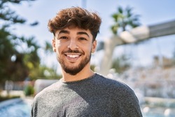 Young arab man smiling happy standing at the city.