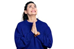 Young hispanic woman wearing casual clothes begging and praying with hands together with hope expression on face very emotional and worried. begging. 