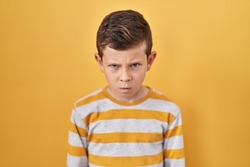 Young caucasian kid standing over yellow background skeptic and nervous, frowning upset because of problem. negative person. 