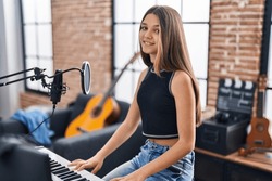 Adorable girl musician singing song playing piano keyboard at music studio