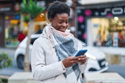 African american woman smiling confident using smartphone at street