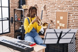African american woman musician playing trumpet at music studio