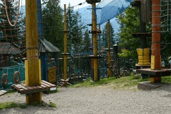 Adventure park with ropes and nets. Cable car among the trees. Climbing rope adventure park.