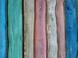 Vertical multi-colored wooden boards. Bright fence