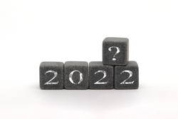 Figures of 2022 with a question mark on stone cubes, what is your goal, overview, business trend, what will happen next year