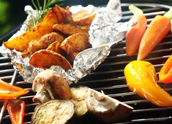 Healthy vegetarian barbecue with fresh vegetable grilling over the coals including bell pepper, carrots, potato and mushrooms
