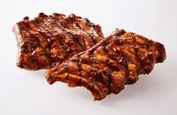 Two portions of delicious spicy marinated spare ribs barbecued over the grill over a white background