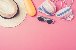 Summer background with straw hat, flip flops, swimsuit and sunglasses. Top view