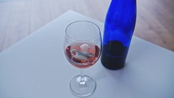 Newborn Baby Sucker Floating in Glass of Rose Wine left on Table by Addicted Drinking Breastfeeding or Expecting Mother Risking Development of Fetal Alcohol Spectrum Disorder