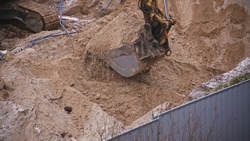 Construction Site Excavator Scooping Dirt Creating Excavation for Concrete Foundation