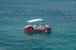 Water taxi – car shaped colorful catamaran boat on the water surface
