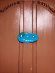 a decoration that says welcome is pasted on the front door of the house