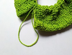 Unfinished circlular pattern crochet scrunchie project isolated on white. Double crochet application on making scrunchie. Green crochet yarn for making scrunchie. Handmade crochet scrunchie progress 
