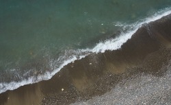 Aerial view of ocean waves braking on a sandy beach. Nature background. Sea water