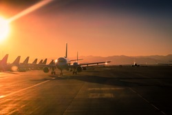 Sun Flare at the airport During Sunset with many Aircraft lined up on the Ramp and Taxi
