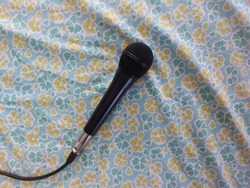 black wired microphone on green fabric with flower pattern. isolated background