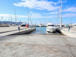 A ramp in the port for launching yachts. Port panorama with many masts.