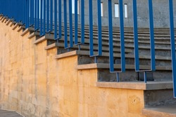 Amphitheater staircase with concrete steps and blue metal railings