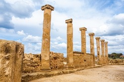 Ruins of an ancient temple in Paphos. Remains of carved marble columns. A row of seven columns as a visiting card of Cyprus.