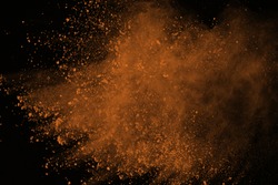 Brown powder explosion isolated on black background. Colored dust splatted.